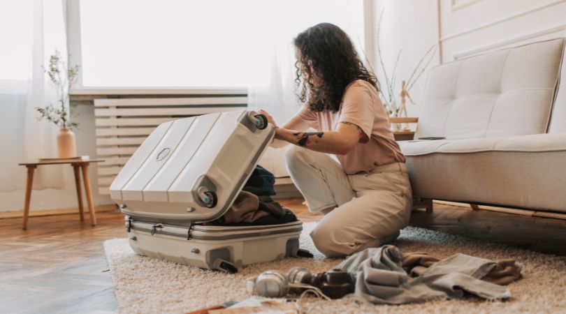 woman packing for a trip in carry-on luggage